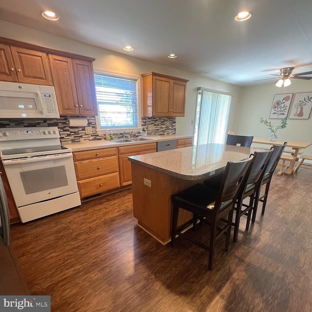54 Ethel Ave, Hummelstown, PA 17036 - kitchen featuring white appliances, a sink, a breakfast bar, dark wood-style floors, and backsplash