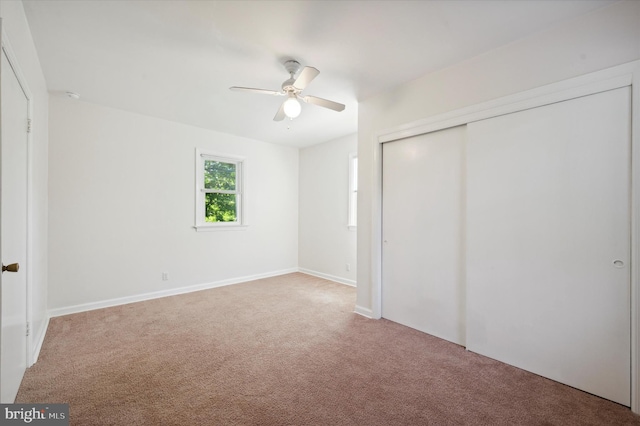 unfurnished bedroom with a ceiling fan, baseboards, carpet, and a closet