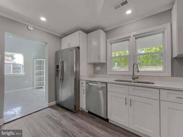 kitchen featuring crown molding, visible vents, light countertops, a sink, and appliances with stainless steel finishes
