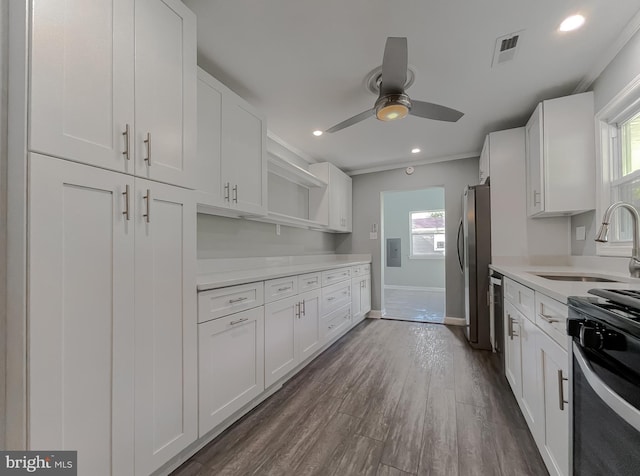 kitchen with open shelves, ceiling fan, white cabinets, a sink, and appliances with stainless steel finishes