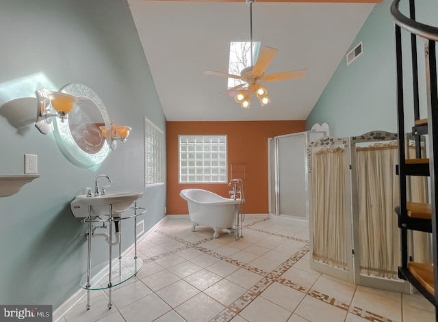 bathroom featuring tile patterned flooring, high vaulted ceiling, a ceiling fan, visible vents, and a soaking tub