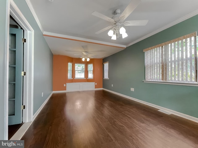 unfurnished room featuring visible vents, crown molding, wood finished floors, baseboards, and a ceiling fan
