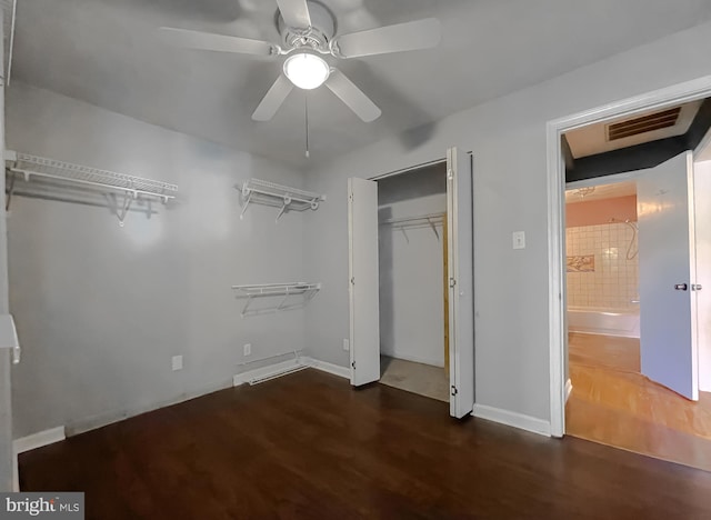 unfurnished bedroom with ceiling fan, baseboards, wood finished floors, visible vents, and a closet