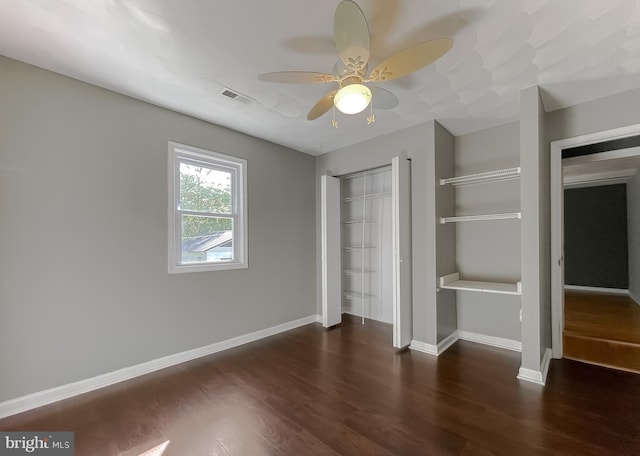 unfurnished bedroom featuring baseboards, a closet, wood finished floors, and visible vents
