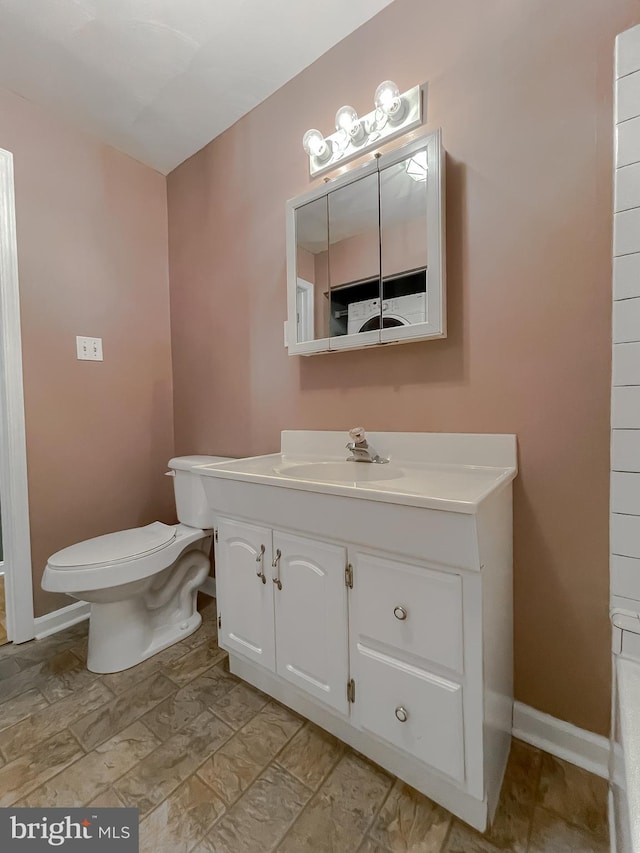 bathroom featuring vanity, baseboards, and toilet