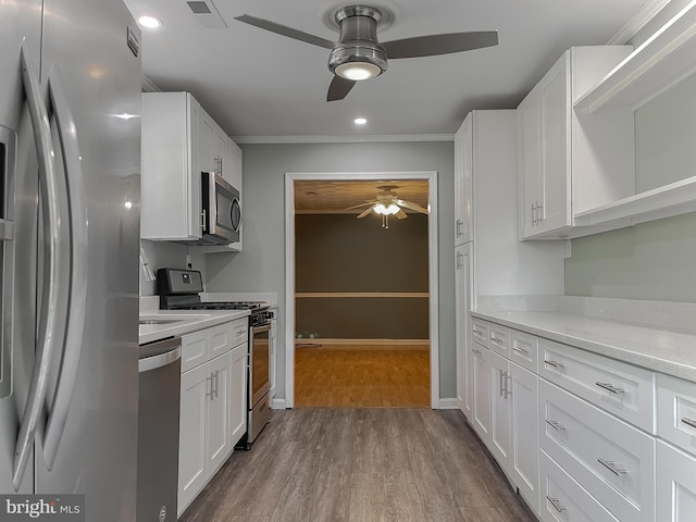 kitchen with a ceiling fan, visible vents, crown molding, dark wood-style floors, and stainless steel appliances