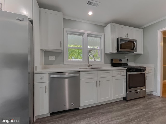 kitchen with a sink, crown molding, stainless steel appliances, and visible vents