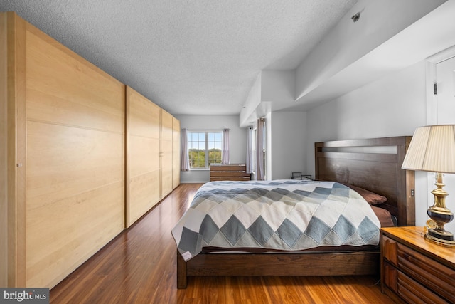bedroom featuring a textured ceiling and wood finished floors