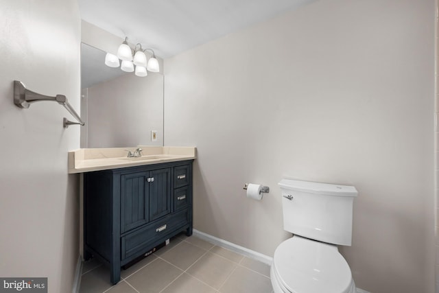 bathroom with tile patterned flooring, baseboards, toilet, and vanity