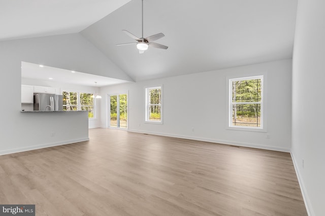 unfurnished living room with high vaulted ceiling, plenty of natural light, ceiling fan, and light wood-type flooring