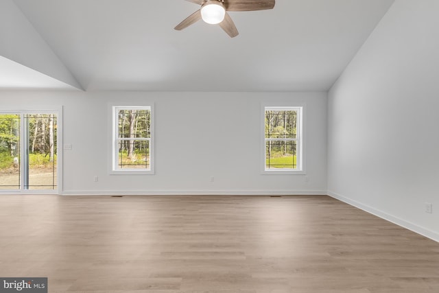 empty room featuring a ceiling fan, a healthy amount of sunlight, and lofted ceiling