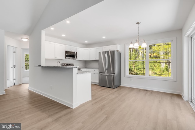 kitchen with recessed lighting, white cabinetry, a sink, light wood finished floors, and appliances with stainless steel finishes