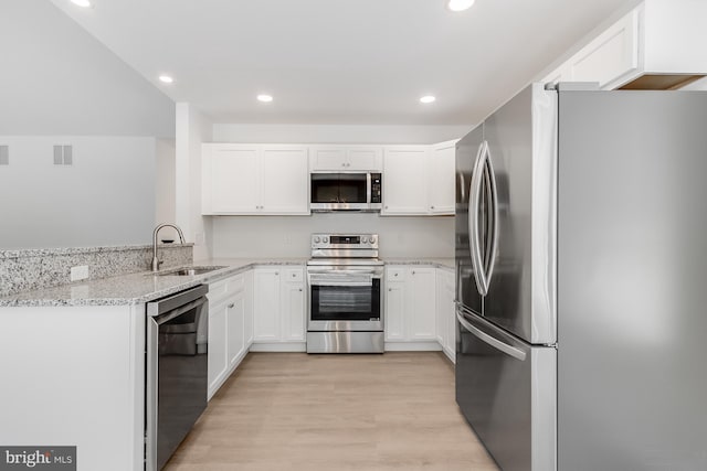 kitchen featuring white cabinets, light stone counters, a sink, stainless steel appliances, and visible vents