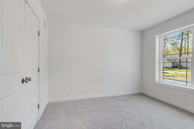 unfurnished room featuring baseboards, visible vents, and carpet