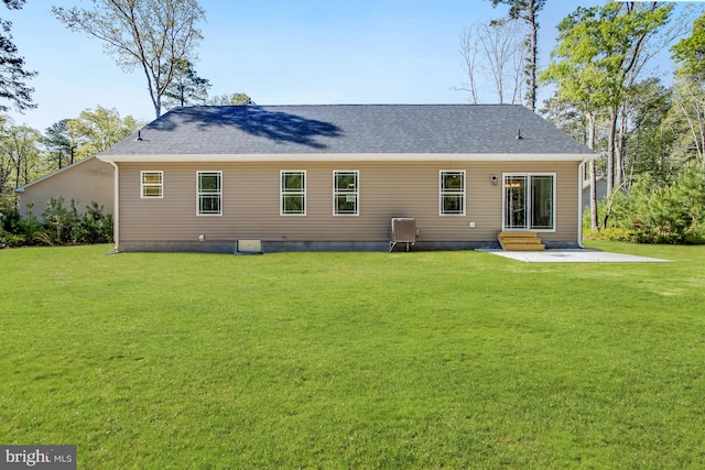 rear view of property featuring a lawn, a patio, a shingled roof, and entry steps