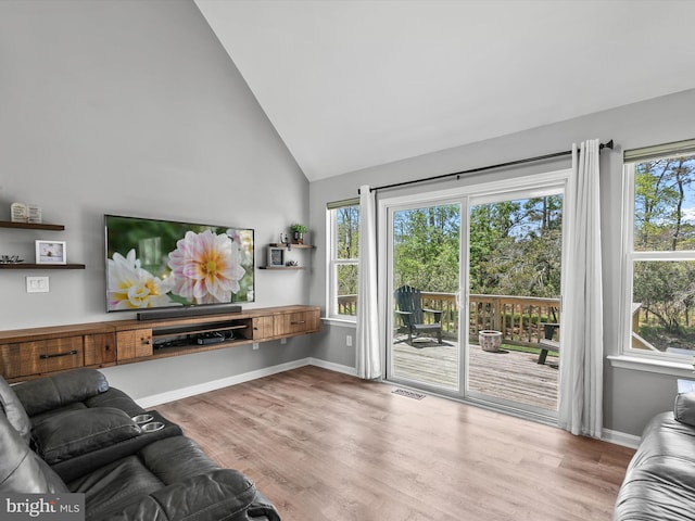 living room featuring baseboards, high vaulted ceiling, visible vents, and wood finished floors