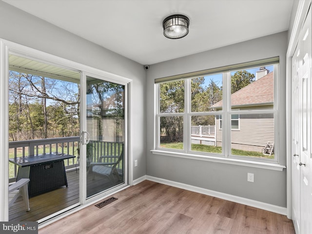 entryway featuring baseboards, wood finished floors, and a wealth of natural light