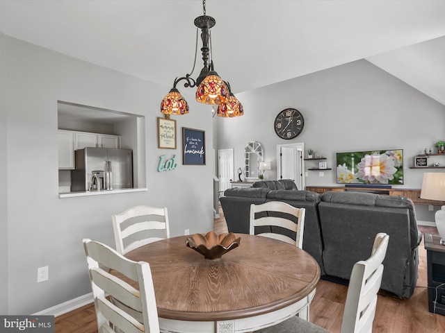 dining room with baseboards, wood finished floors, and lofted ceiling