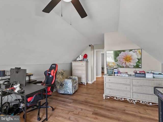 office space with baseboards, ceiling fan, wood finished floors, and vaulted ceiling