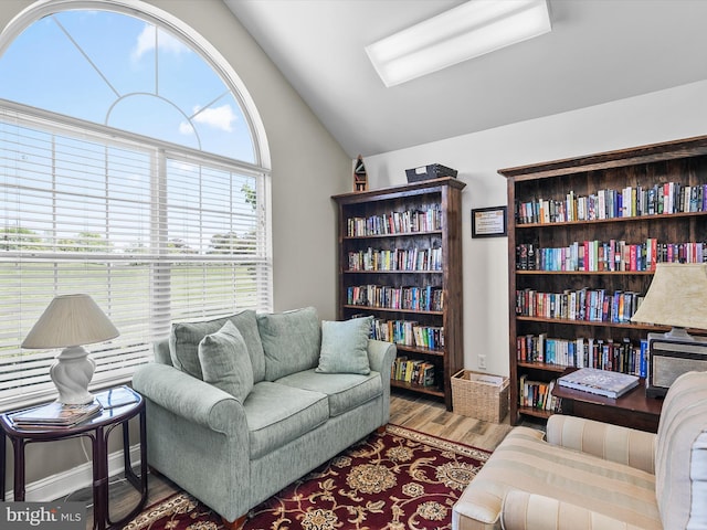 living area with vaulted ceiling and wood finished floors