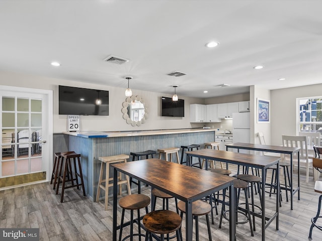 dining room with light wood-style floors, recessed lighting, and visible vents