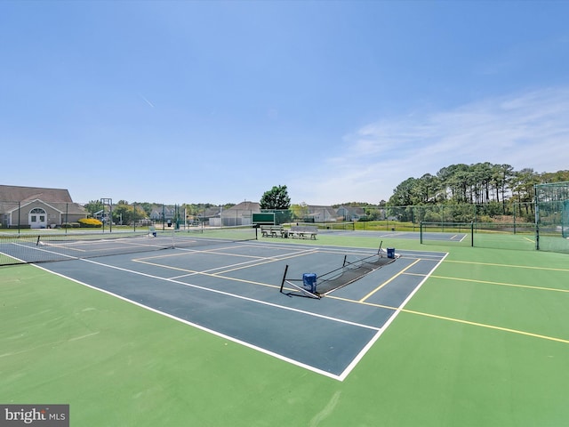 view of tennis court with fence and community basketball court