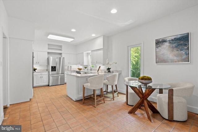 3233 Ellicott St NW, Washington, DC 20008 - kitchen featuring a peninsula, a kitchen breakfast bar, stainless steel refrigerator with ice dispenser, white cabinets, and recessed lighting