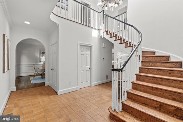 3233 Ellicott St NW, Washington, DC 20008 - stairway with a notable chandelier, baseboards, ornamental molding, tile patterned flooring, and arched walkways