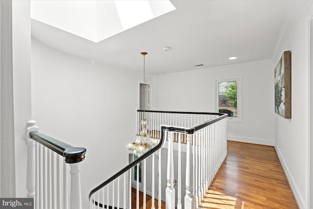 3233 Ellicott St NW, Washington, DC 20008 - corridor featuring a skylight, wood finished floors, ornamental molding, visible vents, and an upstairs landing
