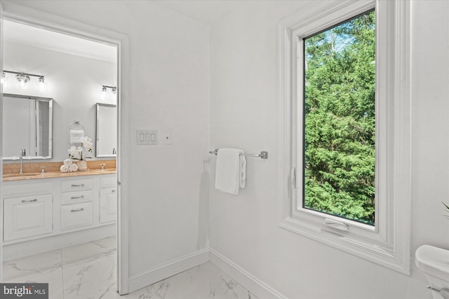 3233 Ellicott St NW, Washington, DC 20008 - bathroom with double vanity, toilet, a sink, baseboards, and marble finish floor