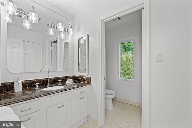 3233 Ellicott St NW, Washington, DC 20008 - bathroom with toilet, vanity, visible vents, tile patterned floors, and baseboards