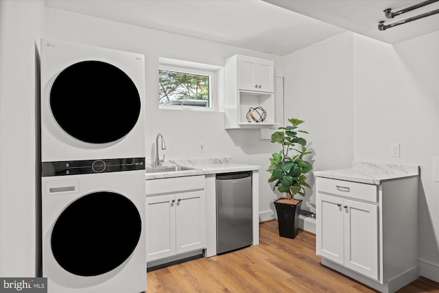 3233 Ellicott St NW, Washington, DC 20008 - laundry area with stacked washing maching and dryer, laundry area, light wood-type flooring, and a sink