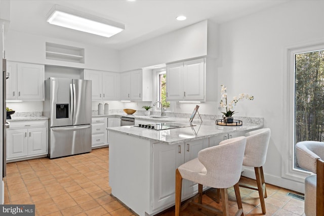 3233 Ellicott St NW, Washington, DC 20008 - kitchen featuring visible vents, a peninsula, appliances with stainless steel finishes, and plenty of natural light