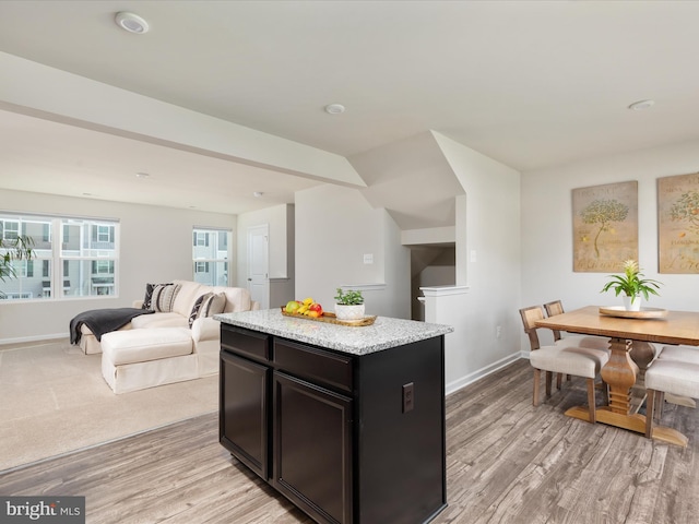 kitchen with light wood-style floors, baseboards, and a center island