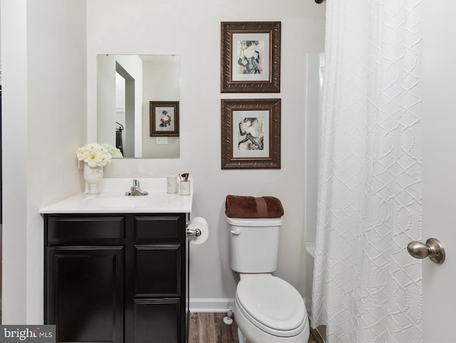 bathroom with vanity, wood finished floors, toilet, baseboards, and a shower with shower curtain