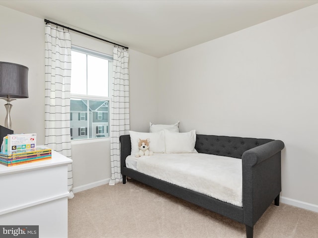 bedroom featuring light colored carpet and baseboards