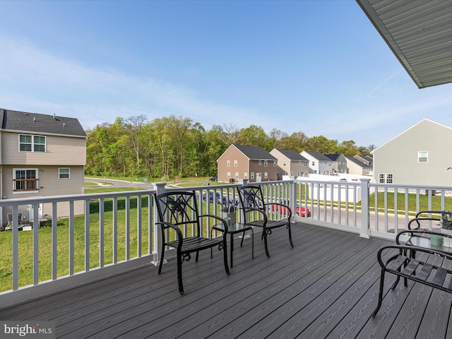 wooden deck featuring a residential view and a yard