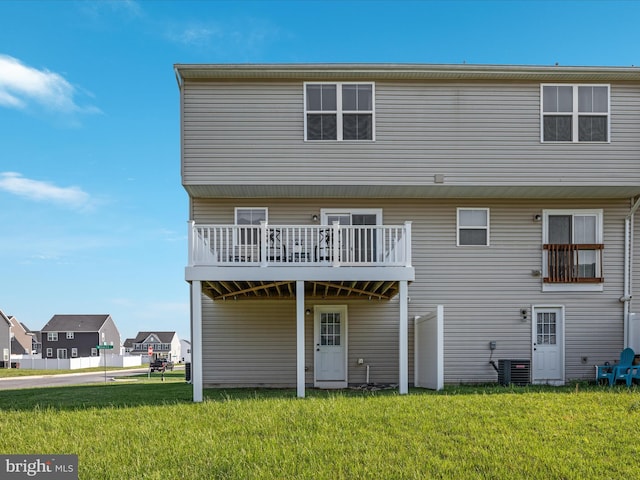 back of house with a lawn, central AC, a deck, and a residential view