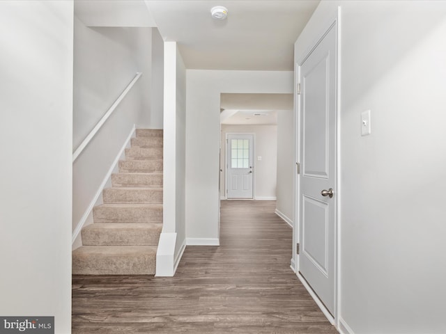 interior space with baseboards, stairs, and wood finished floors
