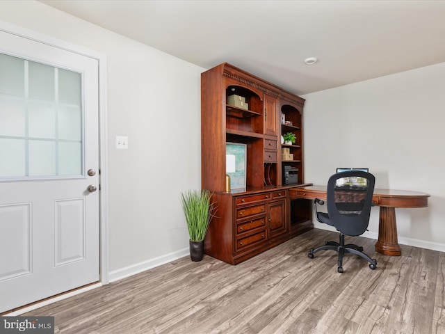office space featuring baseboards and light wood-type flooring