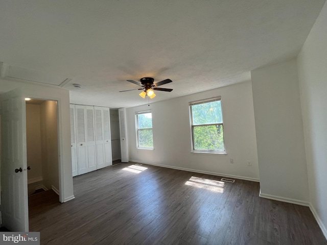unfurnished bedroom featuring baseboards, visible vents, a closet, and dark wood-style floors