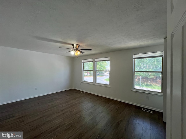 spare room featuring baseboards, a textured ceiling, ceiling fan, and dark wood-style floors