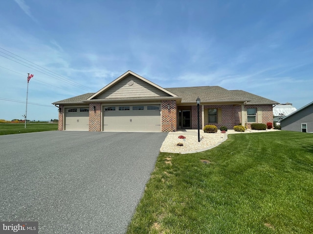view of front of property featuring a garage, driveway, brick siding, and a front yard