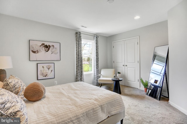 bedroom featuring baseboards, visible vents, light carpet, and a closet
