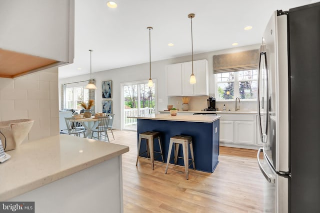 kitchen featuring freestanding refrigerator, white cabinetry, plenty of natural light, and light wood-style flooring