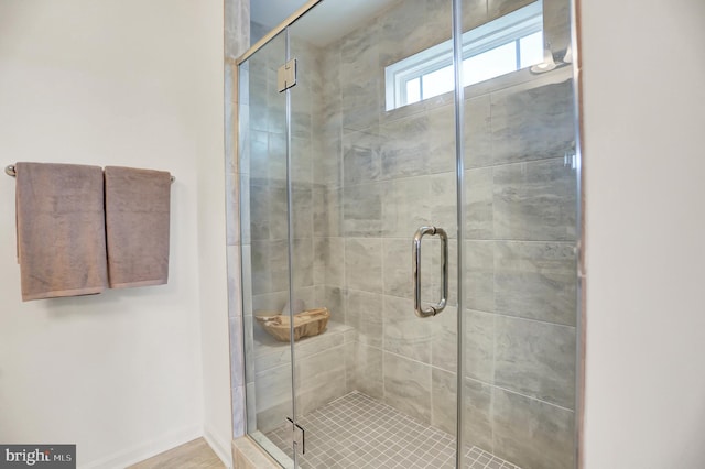 full bath with baseboards and a shower stall