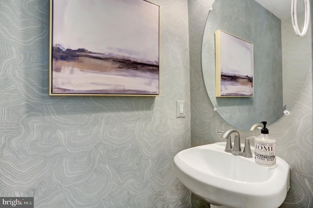 bathroom featuring wallpapered walls and a sink