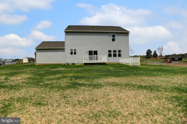 back of property with a yard and a deck