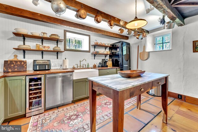 interior space featuring beam ceiling, a sink, beverage cooler, light wood-type flooring, and stainless steel dishwasher