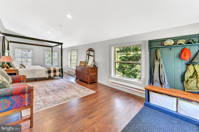 bedroom with a baseboard heating unit, recessed lighting, wood finished floors, and lofted ceiling